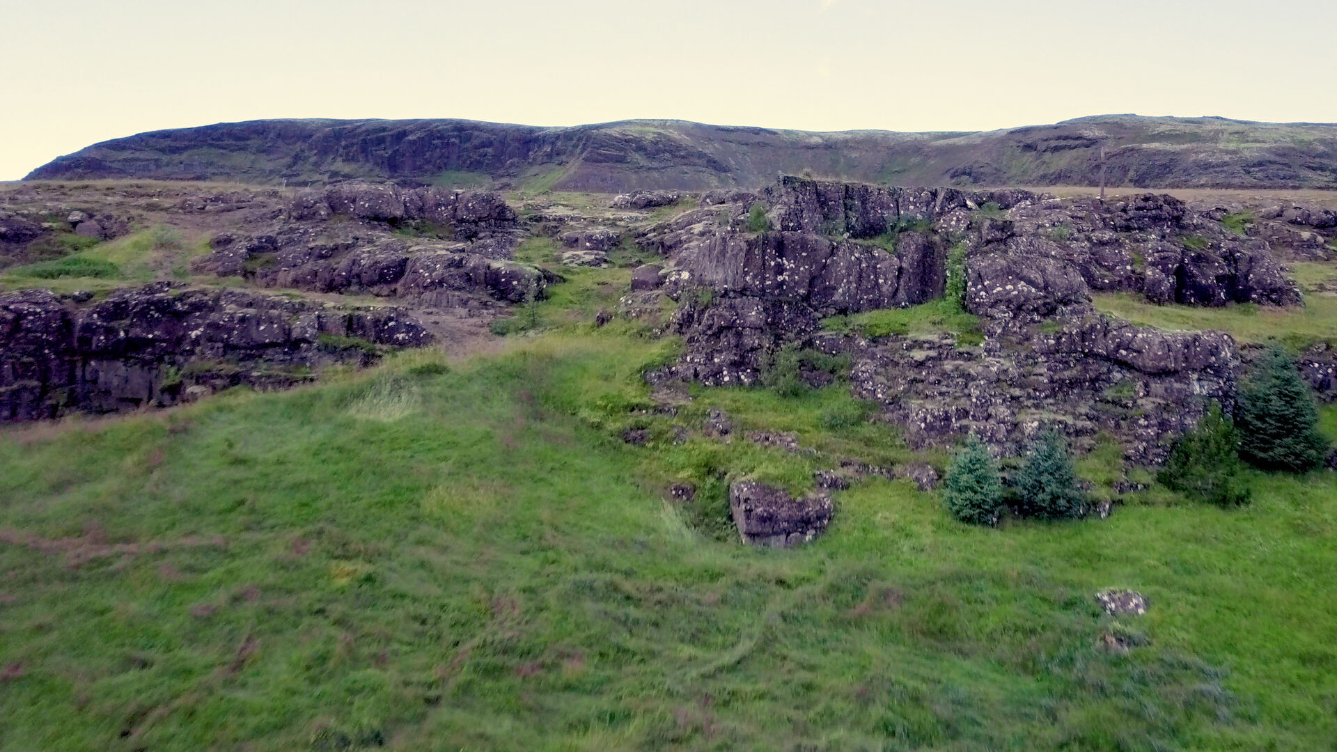 Moss-covered lava cliffs framing the upper part of Riftún